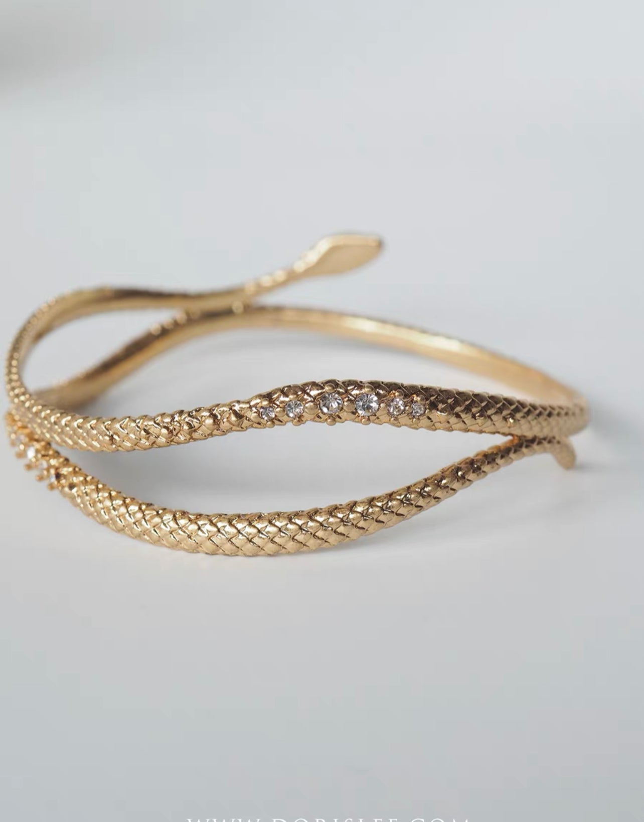 Gold snake entwined snake encrusted bracelet