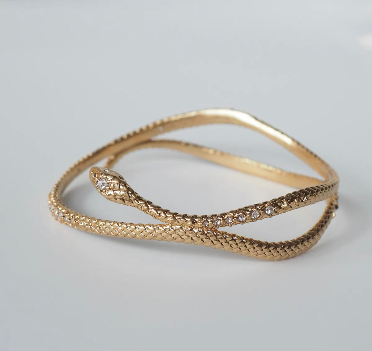 Gold snake entwined snake encrusted bracelet